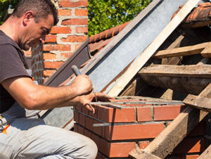 man on roof repairing chimney